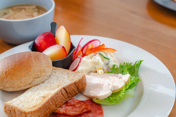 Healthy breakfast plate with bread, ham, chicken and fresh salad
