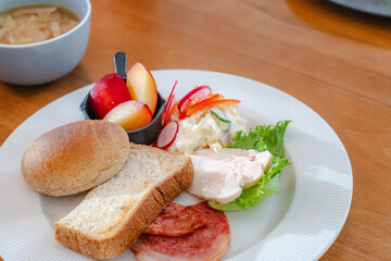 Healthy breakfast plate with bread, ham, chicken and fresh salad
