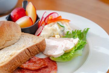 Healthy breakfast plate with bread, ham, chicken and fresh salad
