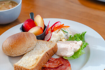 Healthy breakfast plate with bread, ham, chicken and fresh salad
