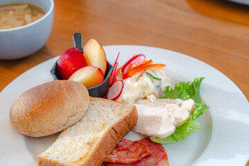 Healthy breakfast plate with bread, ham, chicken and fresh salad

