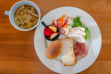 Healthy breakfast plate with bread, ham, chicken and fresh salad
