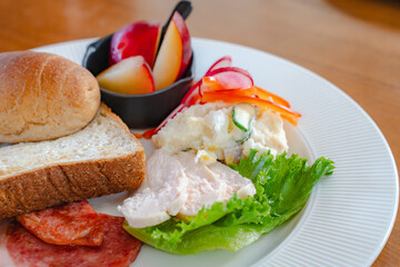 Healthy breakfast plate with bread, ham, chicken and fresh salad
