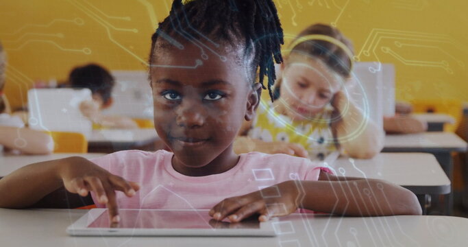 Interacting Black girl using tablet in classroom with white desks yellow chairs circuit overlays - Powered by Adobe