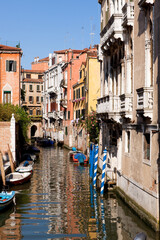 Canal in Venice Italy features colorful buildings and gondolas on a sunny day in the heart of the city