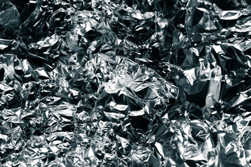 Shiny crumpled foil with metallic abstract look, futuristic texture, chrome surface and cyberpunk style reflective pattern.