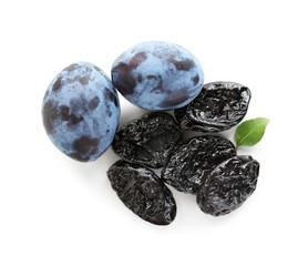 Dried prunes, fresh plums and green leaf isolated on white, top view