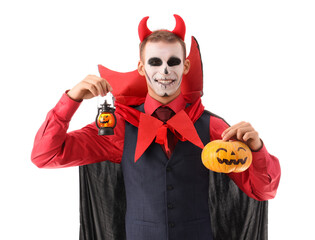 Young happy man dressed as vampire for Halloween with pumpkin and lantern isolated on white background