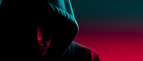 Anonymous hacker silhouette in dark environment with cyber attack theme