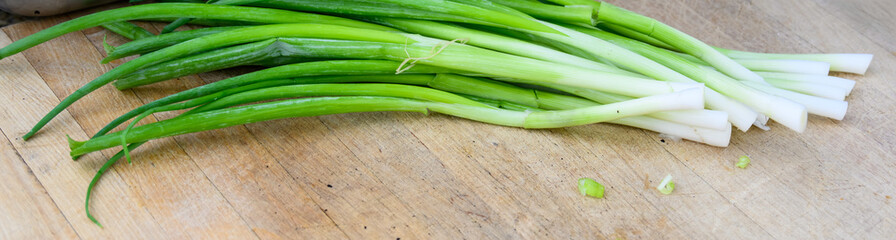 Fresh organic green onions washed and prepared for slicing to use as an ingredient, part of luau dinner preparations 
