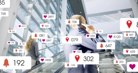 Riding escalator businessman checking smartphone in office atrium, with floating notifications