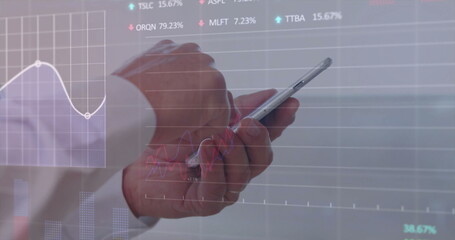 Tapping smartphone while elderly Japanese hands monitoring translucent financial charts in office