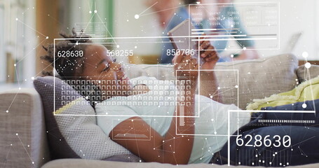 Reclining girl holding smartphone and wearing earbuds on living-room sofa with numeric overlays