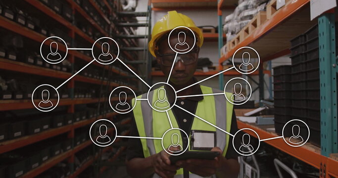 Tapping tablet, worker wearing hard hat and vest checking inventory on shelving with network icons - Powered by Adobe