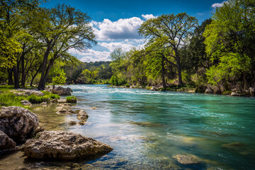 The Guadalupe River in the spring, blue water, green trees, rocks on the shore, clear sky, professional photography in the style