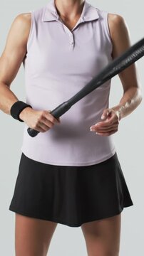 Vertical video: White woman tennis player gripping racket twisting in studio warming up