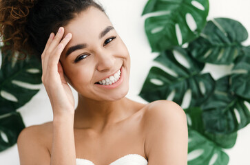 African-american woman with perfect skin over tropical leaves background