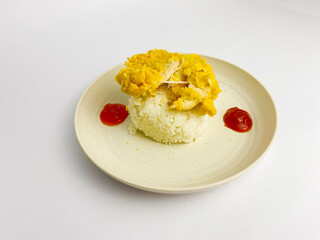 Crispy split chicken fillet with cooked rice and sauce served on round plate, isolated on white background.