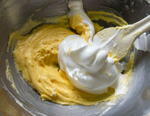 お菓子の生地にメレンゲを混ぜ込んでいる