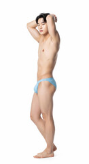 Obraz premium An alluring young Asian man poses confidently in colorful swimwear, showcasing a toned body. Captivating fashion and sensuality in a clean, minimalist studio setting.