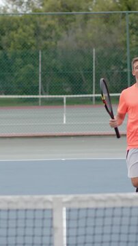 Vertical video: Player pumping fist after win, opponent arriving for racket tap at net walking off