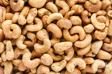 A pile of cashews, perfect for snacking or as an ingredient in cooking. The cashews are whole and have a golden-brown hue.