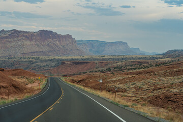 Scenic Highway Journey Through Arid Western Desert with Towering Red C