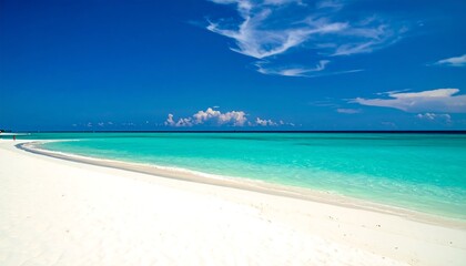 Pristine white sand beach meets turquoise water under a vast blue sky