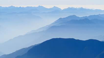 Layered blue mountain ranges fade into soft atmospheric haze image