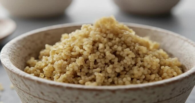 Cooked quinoa in a rustic bowl on a kitchen table