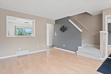 Large open living room with a grey wall and a staircase