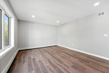 Large, empty room with a wooden floor and white walls