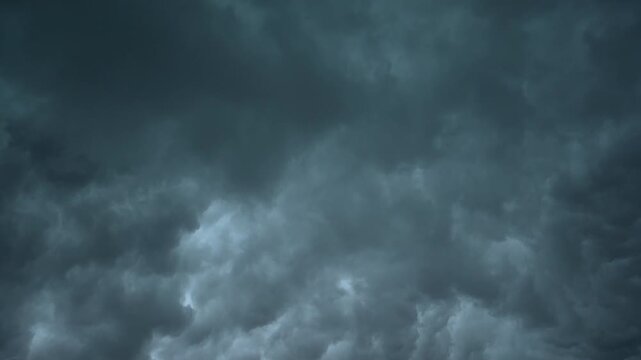 Stormy rainy dark grey blue clouds rolling in the sky. Timelapse