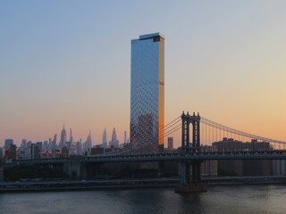 the view from the Brooklyn bridge to the Manhattan bridge with Manhattan skyline, New York at dawn in summer