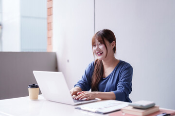 Asian adult woman happily work laptop bright modern home office freelancer achieve business success remote entrepreneur productivity boost digital nomad lifestyle