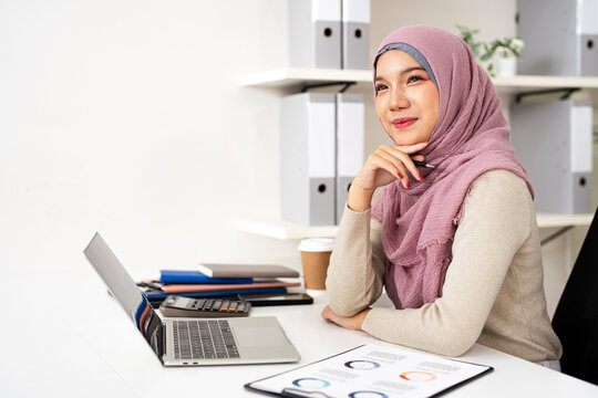 Happy dreamy Muslim business woman in hijab looking away at copy space and dreaming, planning. Smiling smart young lady thinking of new opportunities vision. - Powered by Adobe