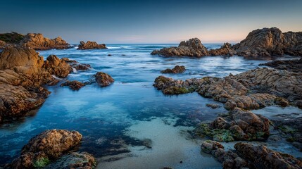 A rocky shoreline with tide pools and gentle evening waves