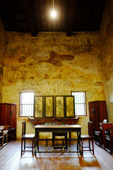 Vintage and rustic grunge concrete wall and wooden floor in literature room with old furniture of Chinese style in Bangkok of Thailand. Vertical photo