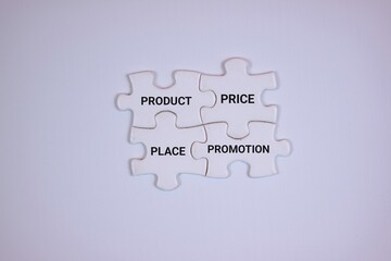 Fototapeta premium Four puzzle pieces displaying product, price, place, and promotion, representing the marketing mix concept. Isolated on white background