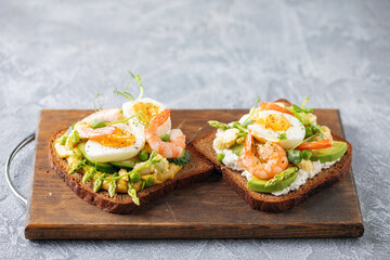 Homemade sandwiches with cheese cream, avocado, cucumbers, shrimp and eggs