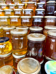 Honey store counter top full of types of honey jars in different colors with copy space for mockup