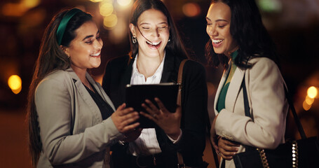 Laughing, night and tablet with business women outdoor together for conversation or planning. App, bokeh and funny with corporate employee working late for discussion or research deadline as friends