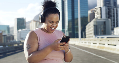 Phone, fitness and woman with music in city to listen to radio, audio and workout playlist. Headphones, runner and plus size person on smartphone for health app, exercise tracker and training outdoor