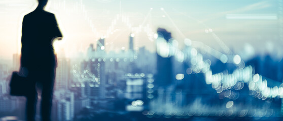 Obraz premium Silhouette of a person with briefcase overlooking a cityscape with financial chart overlay.