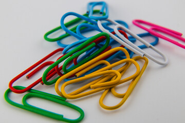 Colorful paper clips arranged in a vibrant pile on a white surface