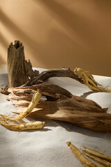 A vertical shot with ginseng root on sand and wooden textures, symbolizing energy, vitality, and the heritage of natural medicine.