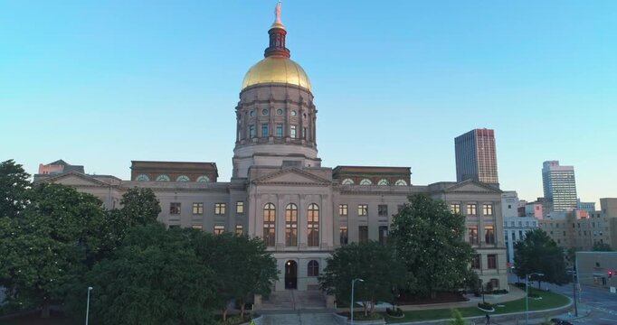 The Georgia State Capitol Building in Atlanta, USA, stands tall against the evening sky. The golden dome shines, representing the state's history and government.