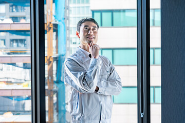 考える作業着を着た男性