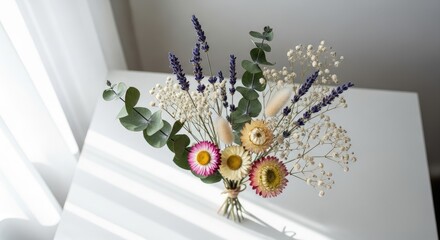 Elegant Dried Flower Bouquet with Lavender, Eucalyptus, Baby' Breath, and Strawflowers, displayed on a white table with natural window light and subtle shadows for a serene and rustic home decor.