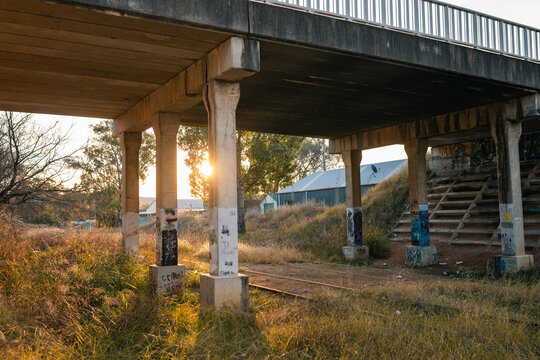 Old rail crossing bridge in small town with graffiti on poles